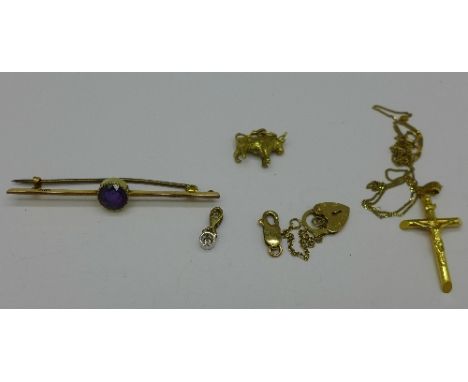 A 15ct gold and amethyst brooch, 3g, a 9ct gold crucifix and chain, 1.7g, two charms, a pendant and a fastener, (total weight