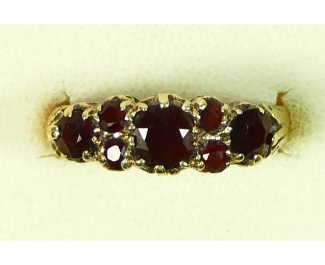 A vintage 9ct gold three stone garnet ring, with small stones between, N, 2.2gm 