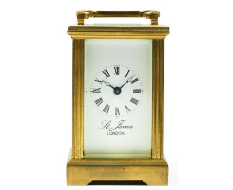 A miniature brass carriage clock with 8 day movement, retailed by James Of London.9cm tall. 