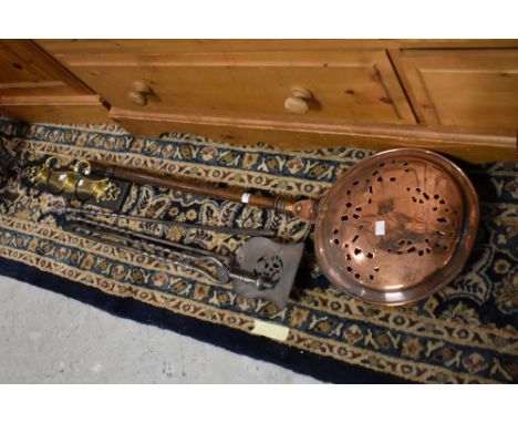 A selection of vintage fire tools, copper warming pan etc