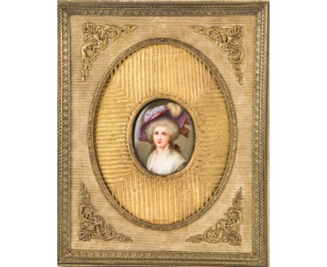  A 19th century porcelain portrait plaque oval with female subject in elegant feathered hat, 2 x 1¾in. (5.1 x 4.5cm.), in a g