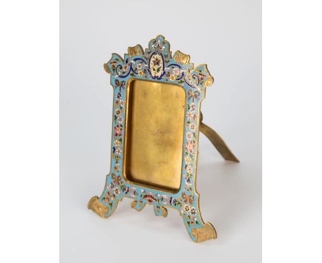  A champlevé enamel photo frame early 20th century, mirror form with floral, ribbon and foliate scroll decoration on blue ena