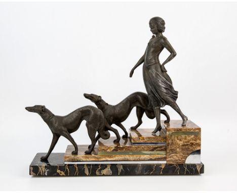  An Art Deco figure signed L. Carvin cast metal, depicting an elegant lady with two greyhounds descending onyx steps with chr