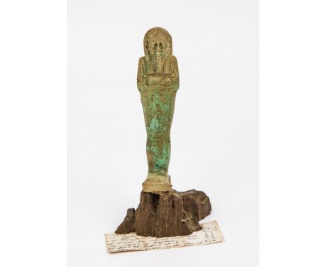  A Egyptian Ushabti figure in turquoise faience, holding a hoe and flail and with hieroglyphs to the front, mounted upon a se