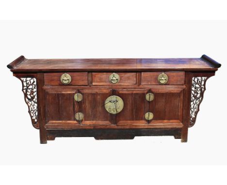  A large Chinese Ming style carved hardwood altar coffer the solid two-plank top with upturned scroll ends, over three drawer