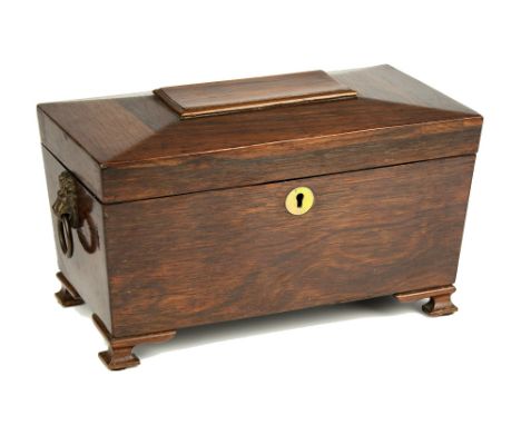  A George IV rosewood tea caddy sarcophagus form with brass lion mask ring handles and later ogee feet, three lidded compartm