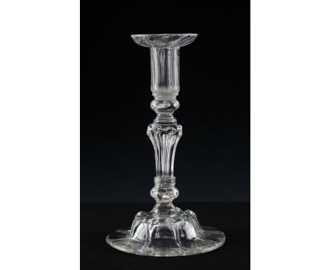  An early 18th century glass candlestick circa 1725, the cylindrical ribbed sconce with saucer rim, set on beaded knop collar
