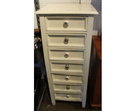 A cream painted tallboy with seven drawer and ceramic designer handles
