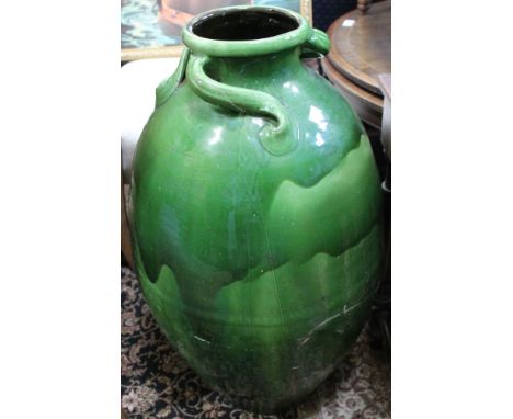 A large ceramic green glazed urn form pot, a/f with staples