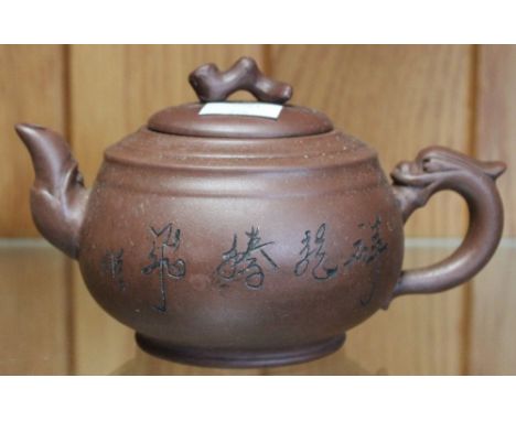 A Chinese red clay teapot, with seal mark to base, incised script and decoration