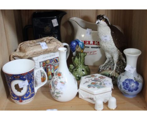 A shelf containing a selection of collectible ceramic items, whisky jugs, a tea pot, a Gleneagles Beswick Osprey etc&nbsp;