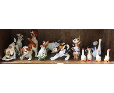 A shelf containing a selection of ceramic animals, dogs, geese and cats with a rogue pheasant. Includes examples by Gobel (17