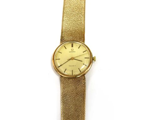 A gentlemen's 9ct gold Omega mechanical bracelet watch, c.1970, 34mm diameter, with a champagne dial, gilt and black baton ho