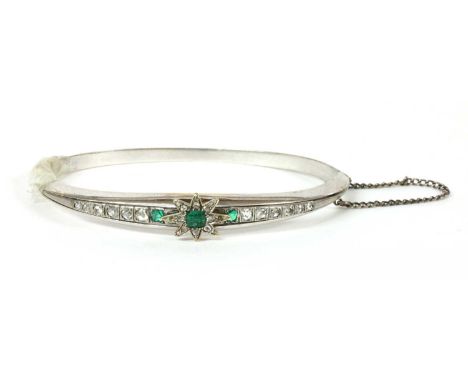 A Continental emerald and diamond set hinged bangle, with an applied emerald and diamond set star centrepiece, with a cushion