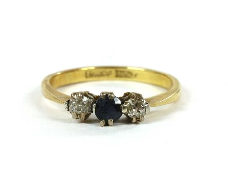 A gold three stone sapphire and diamond ring, a circular mixed cut sapphire with an old brilliant cut diamond at each side, a