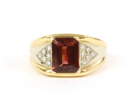 A Continental gold garnet and diamond ring, an emerald cut garnet, with a stated weight of 2.15ct, claw set to tapered should