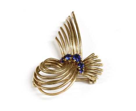 A 9ct gold synthetic sapphire spray brooch, c.1960, a round section wire spray, claw set to the centre with a 'V' of graduate