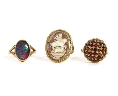 A gold garnet cluster ring, with circular mixed cut diamonds, grain set in a lattice to the circular domed head, tested as ap