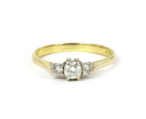 An 18ct gold three stone diamond ring, a graduated row of brilliant cut diamonds, four claw set in white, to yellow tapered s