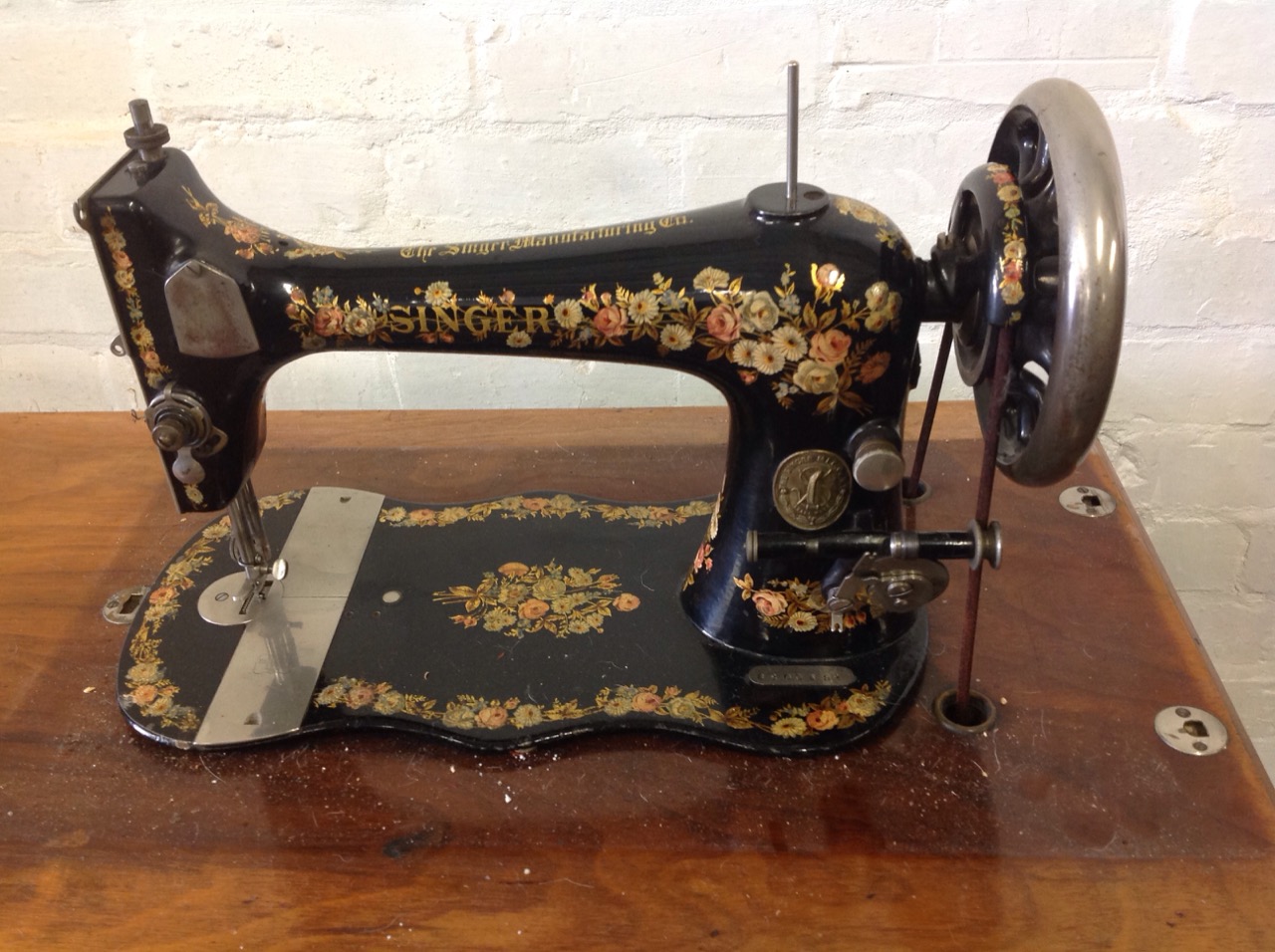 A Victorian Singer sewing machine on stand, with floral decoration to