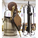 A wrought iron fireside companion set, another brass fireside companion set, metal bucket, wooden