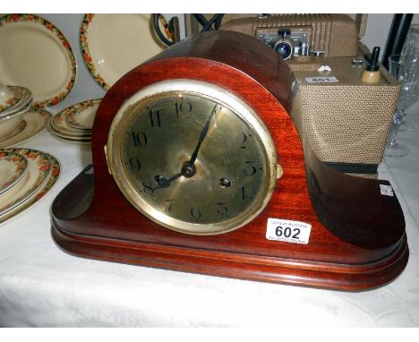A mantel clock with key and pendulum