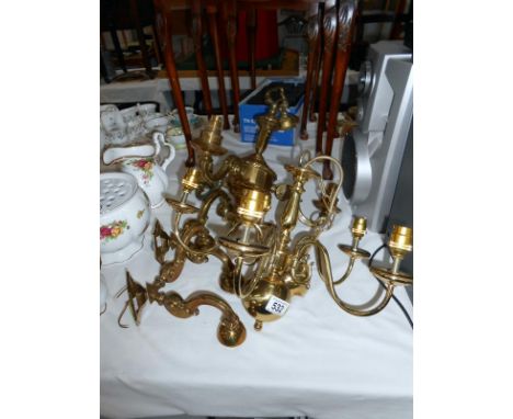 A brass ceiling light with 2 matching wall lights and one other chandelier