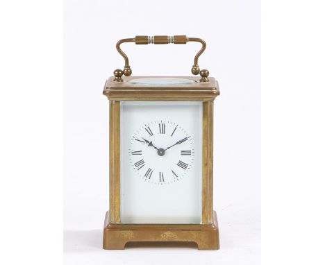 French brass carriage clock, the corniche case with swing handle above an oval bevelled glass escapement viewing window, the 