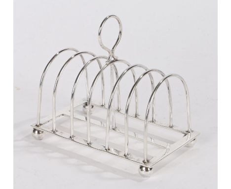 George V silver toast rack, Sheffield 1923, maker William Hutton &amp; Sons Ltd, the loop finial above six arched divisions, 