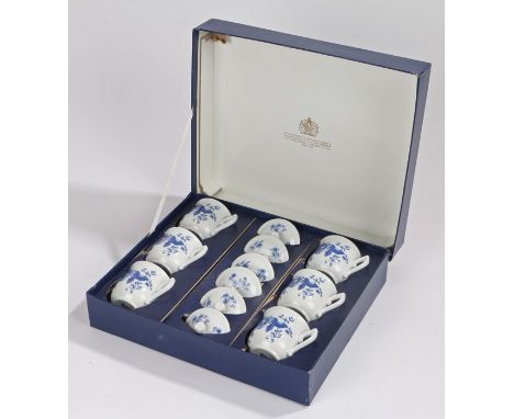 Six Royal Worcester chocolate cups and covers, the white grounds with blue foliate decoration, housed in a fitted box