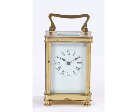 French brass carriage clock, the curved case with swing handle above a rectangular bevelled glass escapement viewing window, 