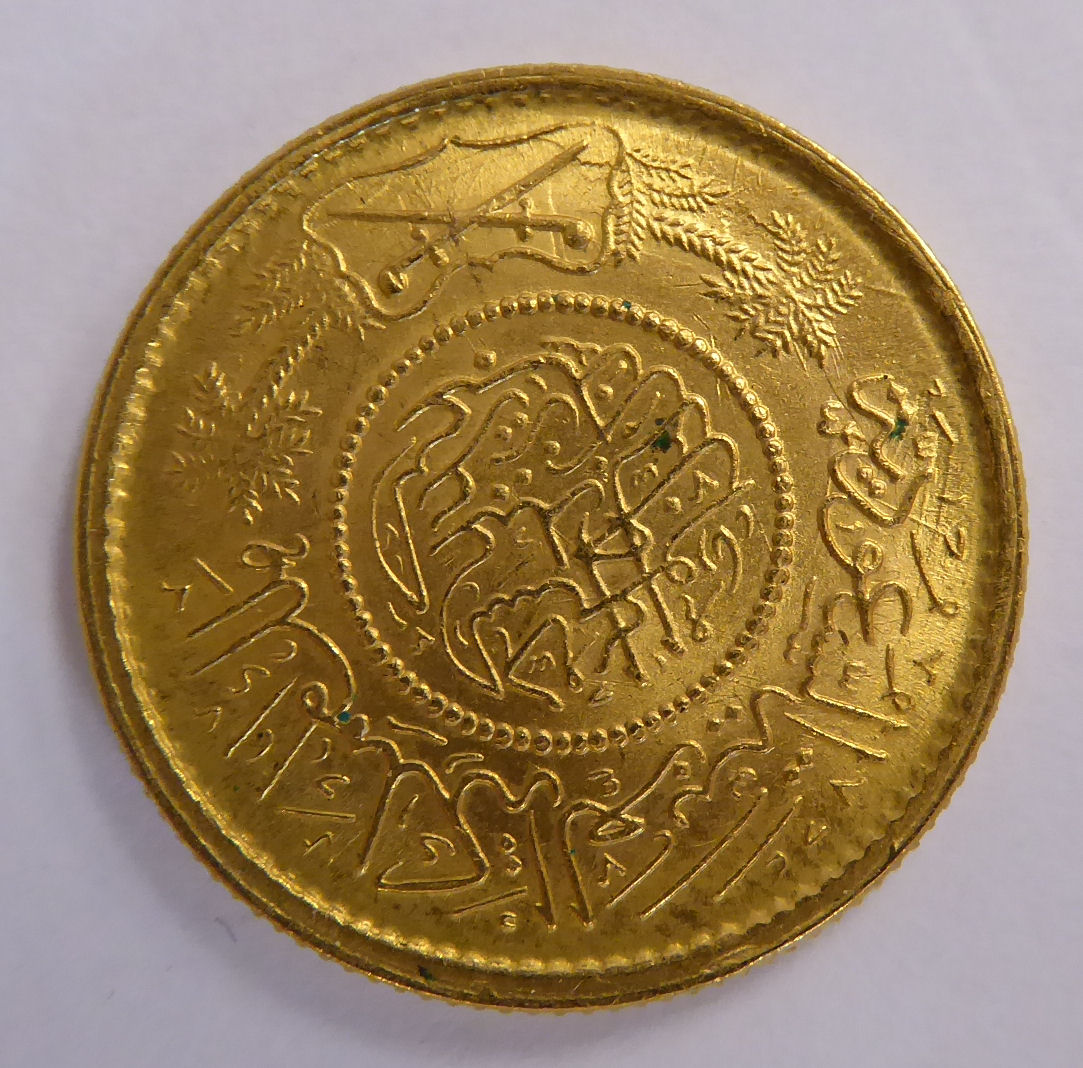 A Persian gold coloured metal coin with a milled border