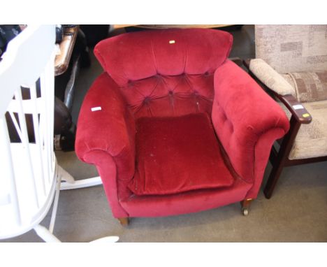 A red upholstered button back armchair