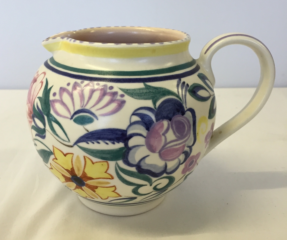 A medium sized Poole Pottery jug 11.5cm tall with rare circular mark