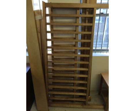 A light wood king size bed with rail style head and foot boards.
