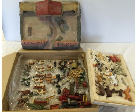A box of vintage lead farm animals and accessories with an early papier mache farmhouse and a tray of plastic farm animals.