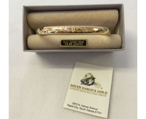 An American South Dakota Black Hills gold bangle. Bangle gold plated marked 14K G F set with 12K gold leaves.