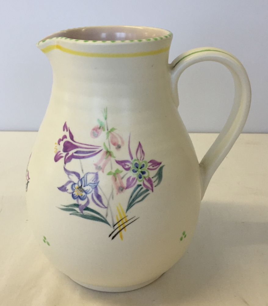 A tall Poole Pottery jug 20cm tall with rare circular mark