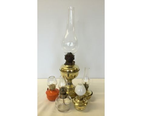 5 vintage oil lamps to include: 1) Large brass Veritas, 19 inches tall. 2) Small brass Veritas nursery with high glass, 7 inc