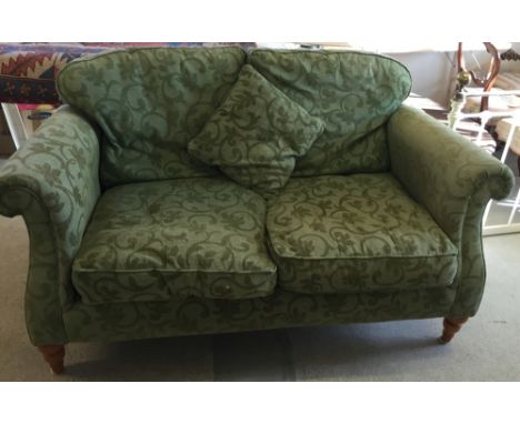 A green 2 seater sofa.