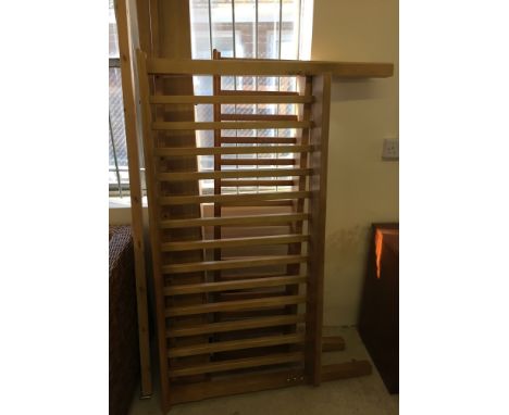 A light wood double bed with rail style head and foot boards.