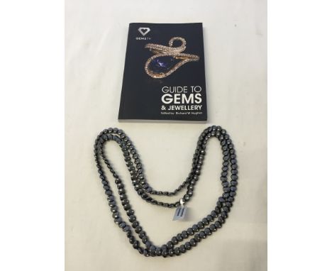 A boxed 48 inch haematite necklace with a Guide to Gemd & Jewellery book.