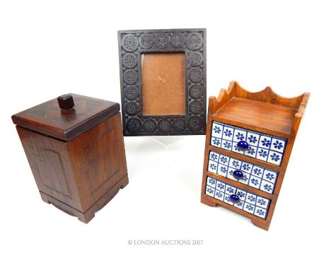 A wooden framed jewellery chest with three delft ceramic drawers (25.5cm high); a hardwood lidded box and a carved wooden pic