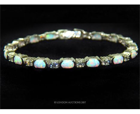 A silver CZ and opal style line bracelet; stamped 925.