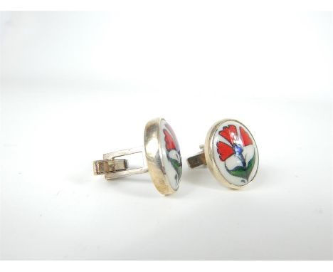 A pair of sterling silver and hand-painted, ceramic, oval, plaque cuff-links each decorated with an Iznik-style hand-painted 