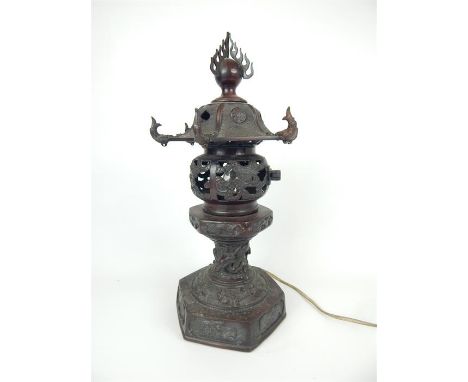 A late 19th / early 20th century Chinese bronze incense burner, converted to a table lamp, the lid surmounted by a flaming pe