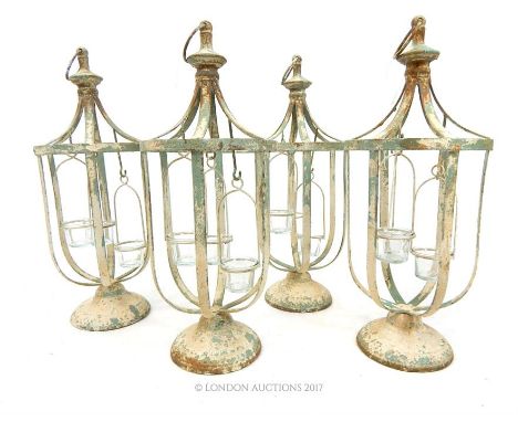 A set of four painted and distressed metal tea light holders of lantern form, 55 x 23 x 23cm.