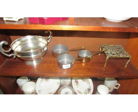 A large silver plate dish, a brass trivet and a set of three copper pans.