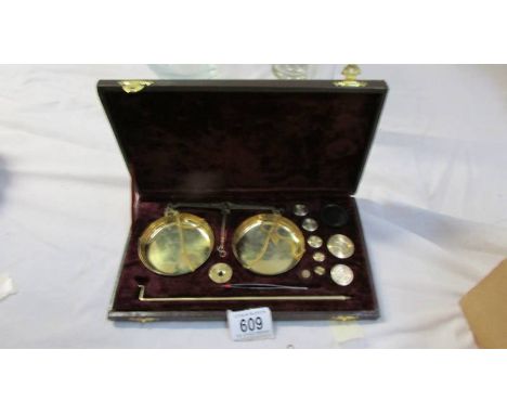 A cased set of brass scales.