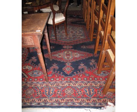 Large Middle Eastern design carpet on a navy and red ground with floral, foliate and geometric decoration.(B.P. 24% incl. VAT